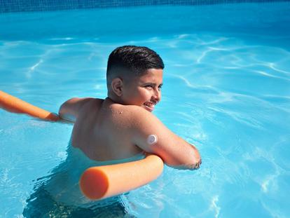 Sensor being worn on the back of the arm of a child swimming